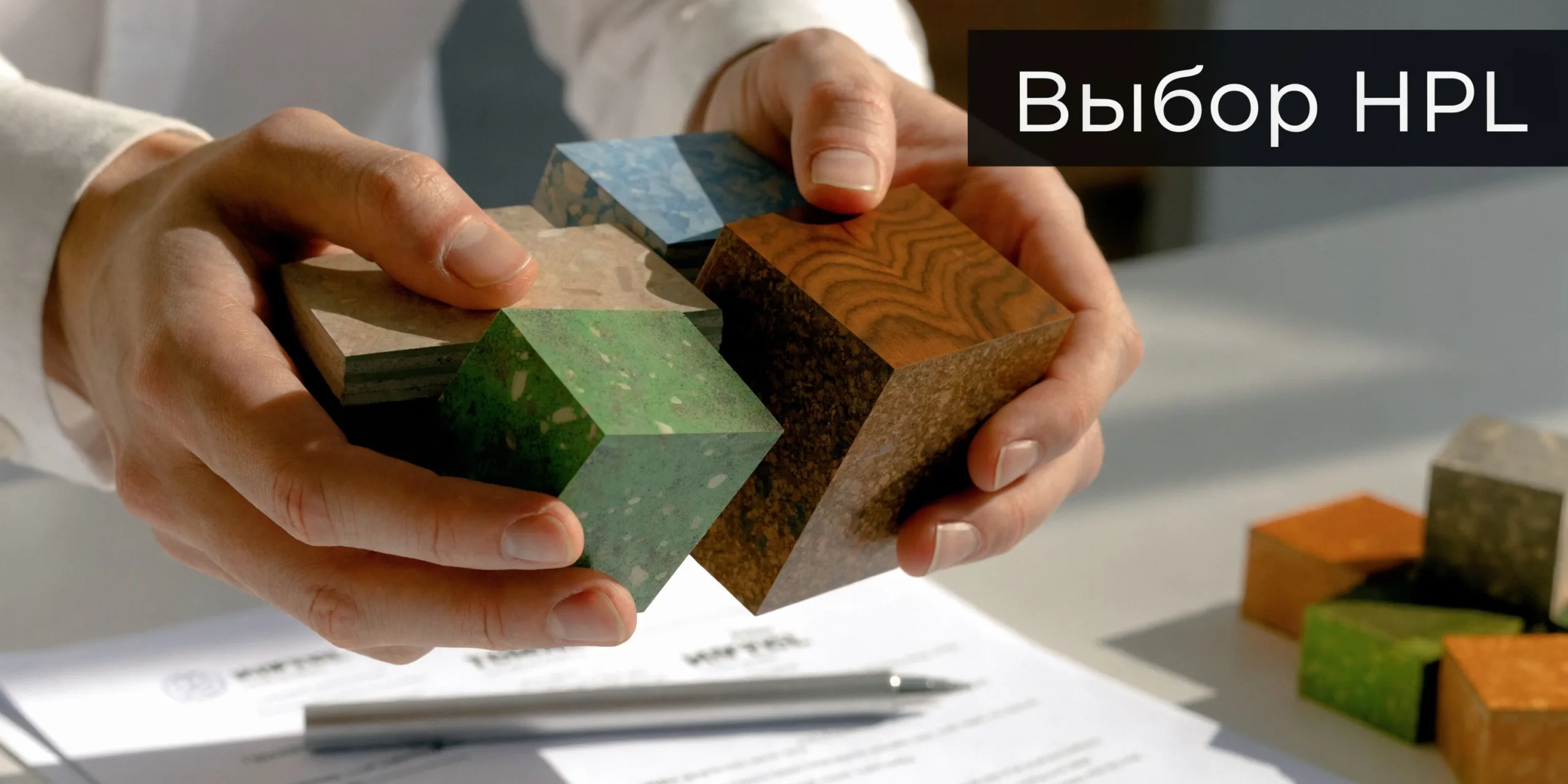 Человек выбирает образцы компакт-плиты HPL различной текстуры и цветов для отделки помещений на рабочем столе